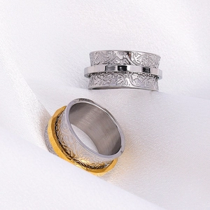 Macro shot of spinner rings with floral relief patterns on elegant white silk fabric