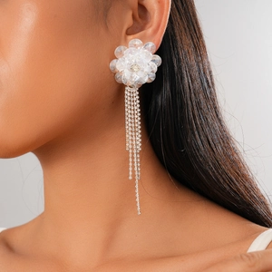 Detail shot of elegant floral crystal tassel earrings worn on ear showing long drop design