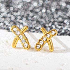 Vue macro de boucles d'oreilles croisées plaquées or 18 carats avec strass étincelants