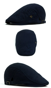 Macro detail of navy cotton flat cap showing 'IS' logo, embroidery, and adjustable strap