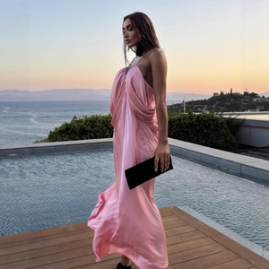 Detail of pink satin halter maxi dress showcasing silky fabric and elegant slim fit