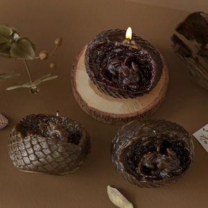 Set of three dragon egg candles with intricate scales and baby dragon carvings