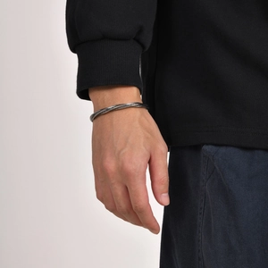Close-up of vintage silver braided stainless steel cuff bracelet on male wrist