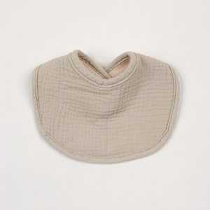 Close-up of khaki multi-layer cotton gauze baby bib showing breathable fabric texture
