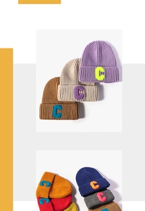Close-up of winter knit beanies featuring colorful C-letter patches and thick texture