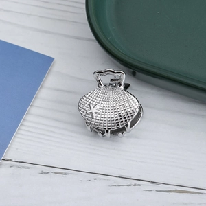 Detail of silver shell-shaped hair claw with starfish accent and polished metallic finish