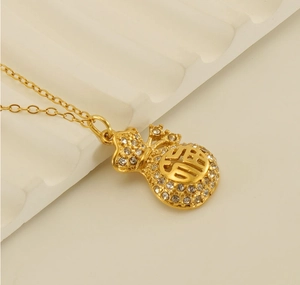 Detailed macro view of gold plated lucky bag pendant with sparkling rhinestones and Fu character