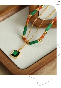 Dettaglio della collana a doppio strato con perline e un ciondolo in pietra verde smeraldo