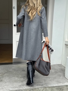 Close-up of a brown patterned leather shoulder bag paired with a gray winter wool coat