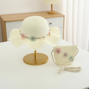Détail d'un ensemble chapeau de paille et mini sac pour enfant avec fleurs élégantes