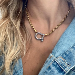 Detail of 18k gold plated box chain necklace with silver horseshoe clasp on model