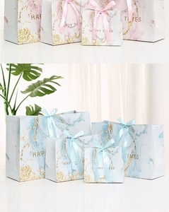 Detail of pink and blue marble gift bags with gold Happy Times foil text and ribbon handles