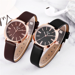 Detail of square quartz watches with leather straps and rhinestone markers on marble