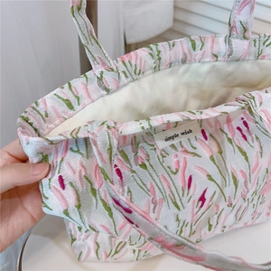 Detail showing tulip jacquard fabric and simple wish woven label on a pink tote bag