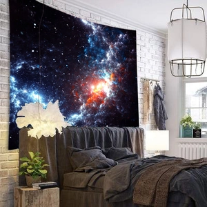 Detailed view of dreamy blue galaxy tapestry hung on a white brick wall in a bedroom