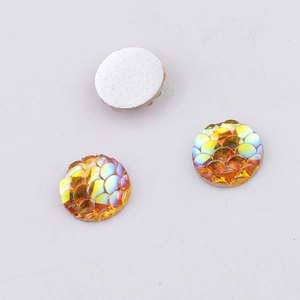 Detailed view of 10mm iridescent orange fish scale resin flatback cabochons on white background