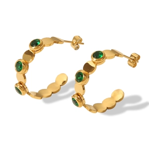 Macro view of 18K gold plated stainless steel C-hoop earrings with green zircon stones