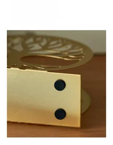 Close-up of golden metal napkin holder base featuring black non-slip silicone pads