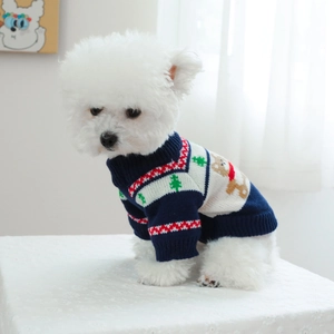 Close-up of pet Christmas sweater with reindeer and tree patterns on navy knit