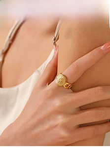 Close-up of golden vintage starburst ring with chain band on woman hand