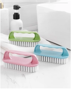Detailed view of plastic cleaning brushes in blue, pink, and green with stiff white bristles