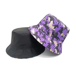 Détail de chapeaux bobs réversibles en noir uni et imprimé licorne avec coutures précises