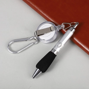Detail view of retractable ballpoint pen with carabiner and black anti-slip grip on desk