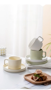 Close-up of elegant ceramic coffee cup with textured vertical stripes and matching saucer