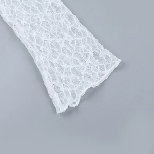 Detalle de encaje blanco transparente con bordado floral delicado y textura de malla