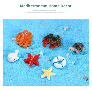 Detailed view of resin sea creature figurines including octopus and crab on blue sand
