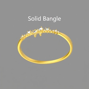 Detail of closed bangle with shimmering teardrop cubic zirconia and golden finish