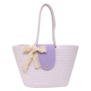 Pink and white woven tote bag with purple flap and beige lace bow on white background