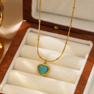 Vintage gold heart pendant necklace with blue gemstone and beaded chain link