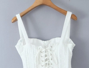Detail von weißem Spitzen-Camisole-Top mit Metallösen und vorderem Schnür-Design