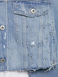 Détails de la veste en jean bleu clair avec strass brillants et bords effilochés
