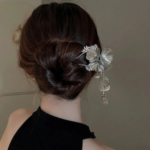 Silver flower hair pin with tassel and crystal accents on black elegant bun hairstyle