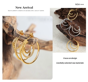 Detail of multi-layer C-shaped hoop earrings featuring smooth and twisted textures