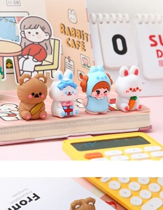 Set of four cute cartoon bear and bunny desk figurines on a pink stationery notebook