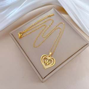 Luxurious gold heart necklace with heartbeat wave design on elegant white silk background
