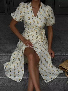 Detail of floral puff sleeve midi dress featuring yellow tulip print and waist tie closure