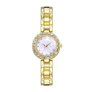 Detailed close-up of a gold-tone watch with sparkling rhinestone bezel and MOP dial
