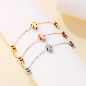 Detailed view of hollow girl charms in gold, rose gold and silver on stainless steel chains