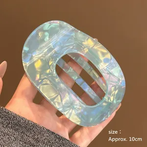 Detailed view of a 10cm large iridescent light blue acetate hair clip with hollow design