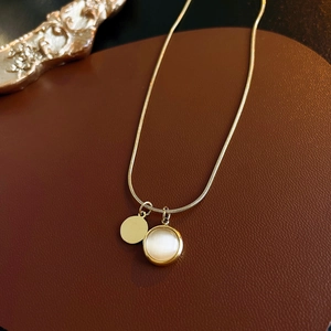 Detail of gold snake chain with double opal and round disc pendants on leather