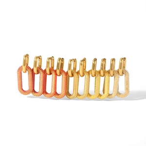 Detail of square link earrings with a gradient metallic finish from red to gold