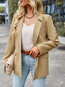 Outdoor street shot of khaki single-breasted blazer with lapel and a loose fit cut