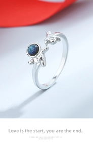 Macro shot of astronaut couple ring with blue glass helmet and adjustable silver band