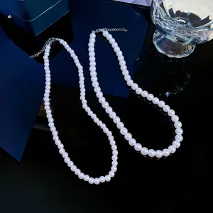 Close-up of elegant white pearl necklaces with silver clasp on a black luxury display