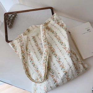 Detailed view of the orange floral cotton tote bag showing the interior label and lining