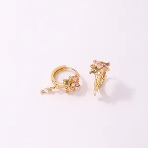 Détail macro de boucles d'oreilles fleur dorées avec zircons colorés et dimensions